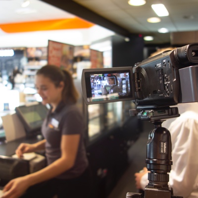 POS user at till in gas station is filmed for user research observation study