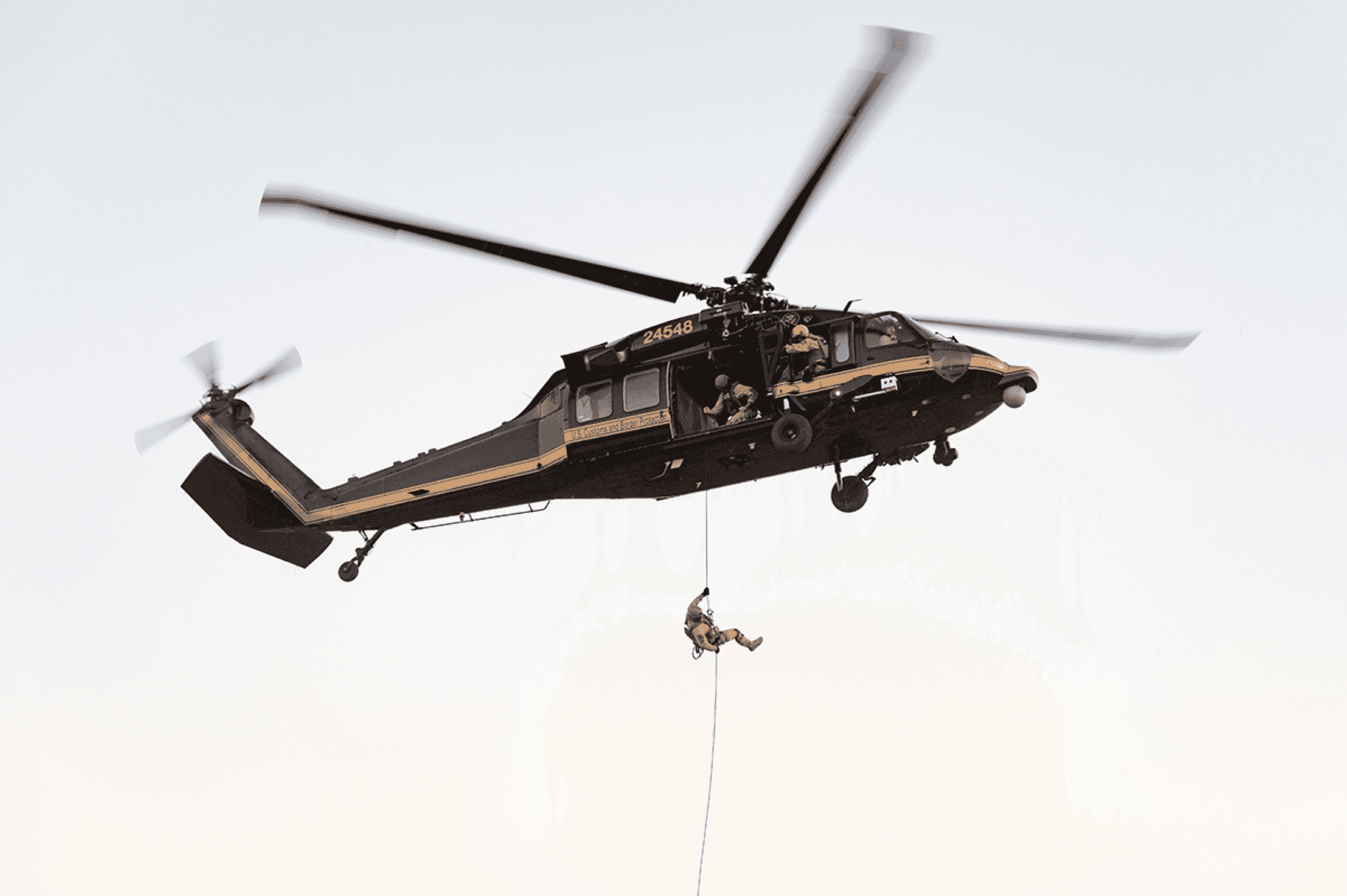 Police officer roping out of helicopter during operation with intelligence software