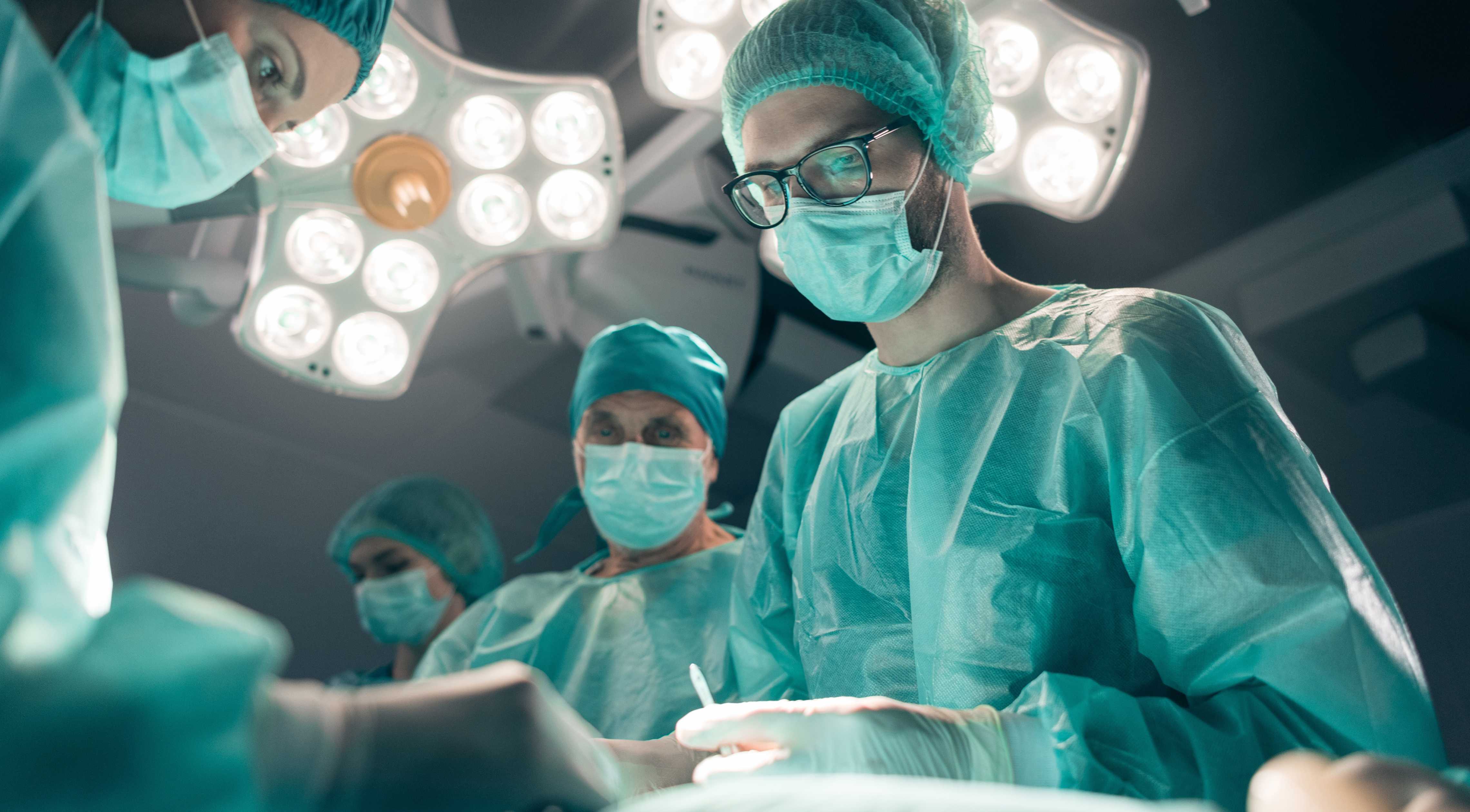 Cover of UX design case study showing surgeons in the operating room with lights overhead.